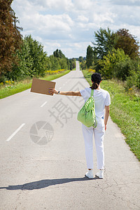 一个背着背包的漂亮女孩站在路边 刹车 搭便车 冒险 旅游 独自一人图片