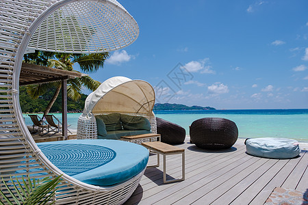 热带岛屿 拥有海滩和棕榈树 在的海滩上设有带椅子的餐厅 叶子 冲浪图片