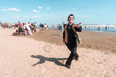 一位身着黑衣 身着花背心的拉丁男子的画像在跳舞 对着镜头飞吻 拉丁美洲暑假的党派理念图片