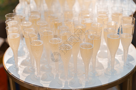 欢迎饮料区 一次性塑料酒杯中装有香槟 白色桌子上有许多酒杯 商务人士餐饮及婚宴 宴会 庆祝图片