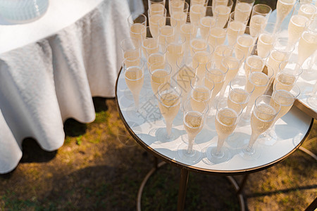 白桌上有许多葡萄酒杯 为商界人士提供餐饮和婚礼仪式 欢迎在可支配塑料红酒杯中加香槟的饮料区 食物 玻璃图片