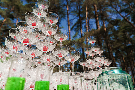 为婚礼喝鸡尾酒 夏日在森林里举行的商务会议上 里面放着香槟和红樱桃的大眼镜金字塔图片