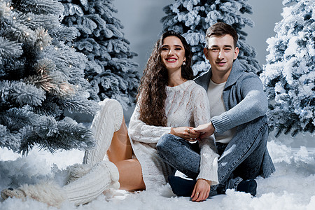 新年的爱情故事 夫妻亲吻和拥抱 冬天在圣诞树附近快乐的年轻情侣 走 前夕背景