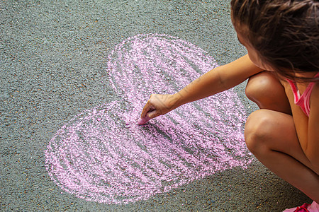 儿童用粉笔在沥青上画了一颗心 手 太阳 快乐的图片