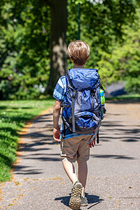 男孩在公园里徒步旅行 带着巨大的背包图片