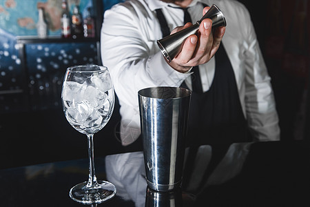 专业酒保的手把糖浆倒进一个测量杯子的抽筋器 装在金属工具中 用于准备和搅拌饮料酒精鸡尾酒和带冰块的眼镜 餐厅 摇床图片