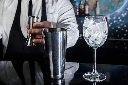 专业酒保的手把糖浆倒进一个测量杯子的抽筋器 装在金属工具中 用于准备和搅拌饮料酒精鸡尾酒和带冰块的眼镜 寒冷的 制作图片