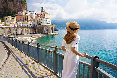 阿马尔菲海岸的假期 欣赏阿马尔菲海岸 Atrani 村景色的美丽时尚女孩的背影 在意大利的暑假图片