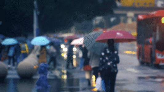 窗边背影雨天大街上打伞骑自行车的路人GIF高清图片