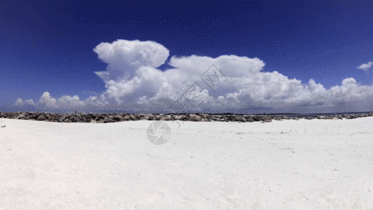 白沙滩边上的白云翻腾延时摄影GIF图片