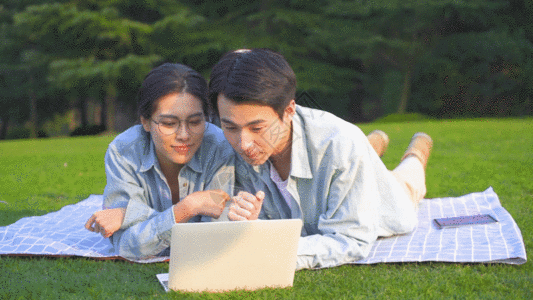大学生在草地上使用电脑学习GIF图片
