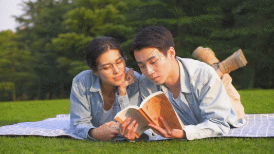 情侣读书情侣在草坪上趴着看书GIF高清图片