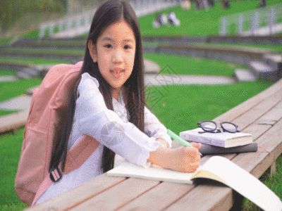 儿童书包孩子趴在桌子上画画GIF高清图片
