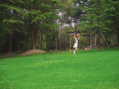 小女孩拿着风筝在草地上跑GIF图片