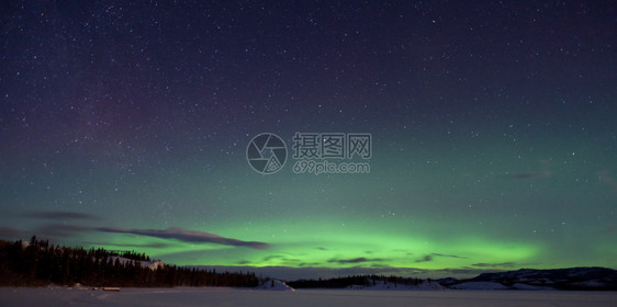 绿色的北光Auroranotalis亚风暴几朵云和许多星在雪图片