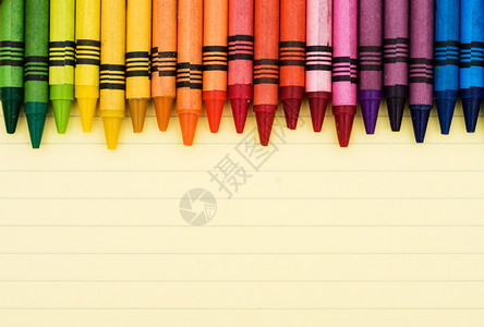 一张横格纸上的彩色蜡笔教育背景图片