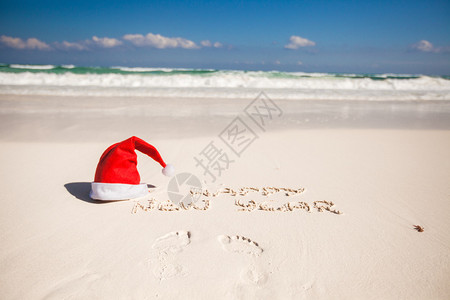 加勒比海白色沙滩上的圣诞老人帽和沙子上插画