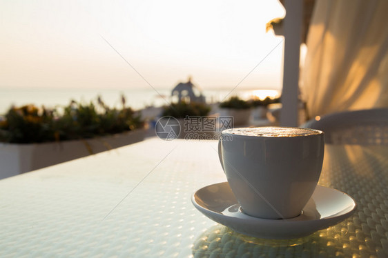 在海滩上喝杯咖啡放松一下咖啡馆里的美味咖啡在海滩上度过了一个美好的早晨旅游和烹饪杂志海报背景图片