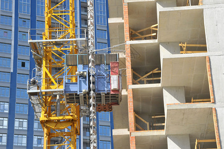 使用起重机升降机金属束砖头金属梯子和混凝土建造高楼公寓背景图片