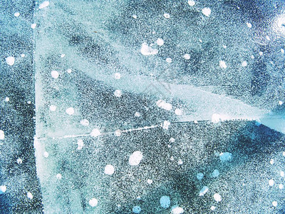 气泡冻结在薄冰中五颜六色的冰块与太阳光线反射抽象的冰纹图片
