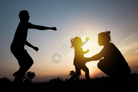 幸福的家庭父亲和母亲在日落图片