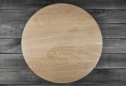 木制背景上的圆形比萨板图片