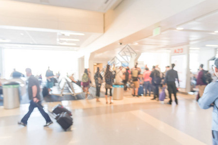 在美国德克萨斯州达拉斯沃思堡机场等候区站着和坐在行李箱上的模糊乘客模糊的不同人群排队作为抽象的交图片