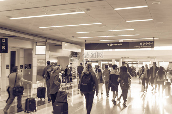 复古色调模糊了一群忙碌的人在晨光中带着行李在机场散步抽象背景乘客或带行李的游客在走图片