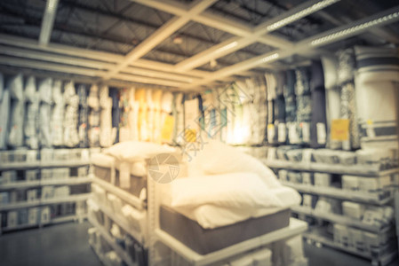 家具店的床上用品床单棉被羽绒被枕套的模糊抽象广泛选择在准备组装的家居饰品仓库中分散图片