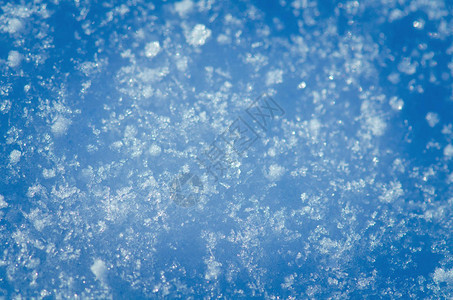 阳光明媚的日子下雪抽象闪亮的雪背景蓝图片