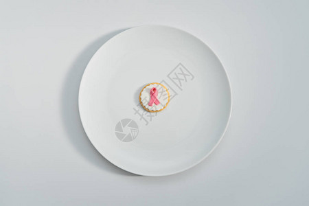带有粉红丝带的饼干作为在白色背景上的白板上与乳腺癌作斗争的标志2月4日国际癌症日的抽象概图片