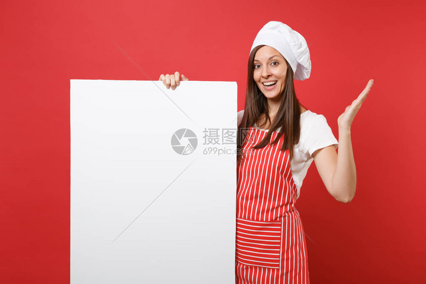家庭主妇女厨师面包师穿着条纹围裙白色T恤红色背景中突显的无边帽厨师帽女人拿着大的白色空白广告牌宣传内容模拟图片