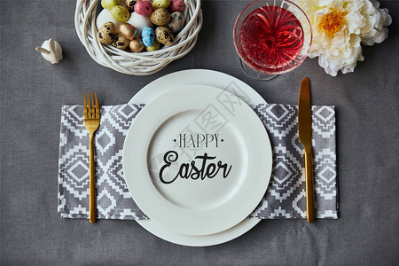 配有装饰彩蛋和欢乐复活节牌照的复活节餐桌设置图片