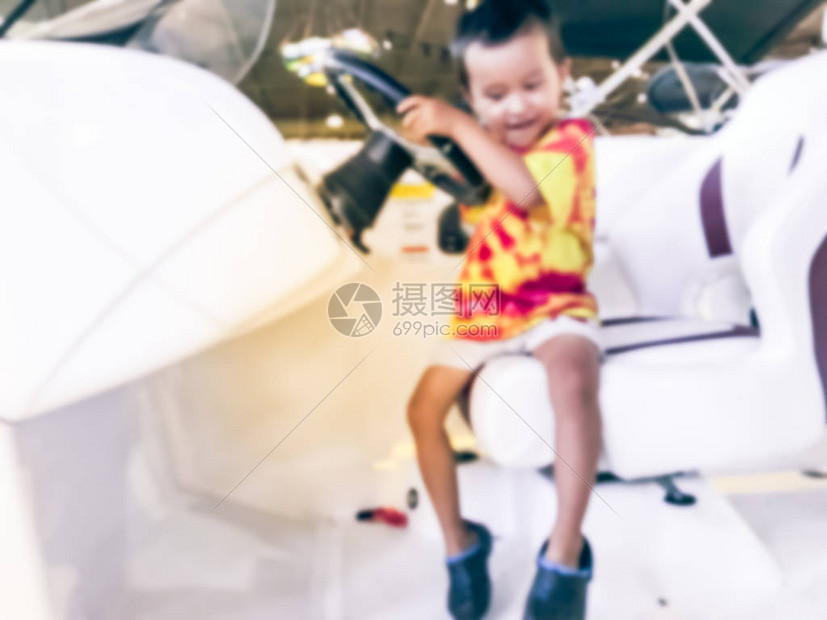 抽象模糊的亚洲小孩男试图在美国得克萨斯州大型户外商店展厅驾驶该船图片