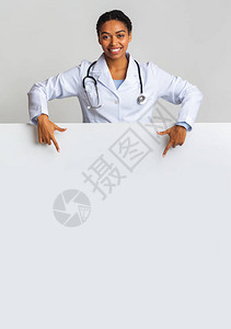 微笑的非洲女实习医生指着空白广告板图片