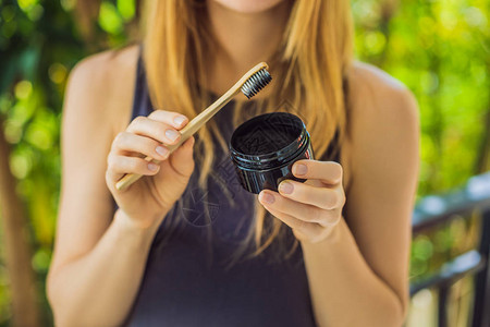 年轻女子刷牙使用活炭粉刷牙和美白牙图片