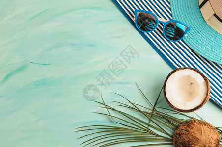 夏季作文或布局热带棕榈叶帽子眼镜沙滩巾海绿色背景上的椰子夏季和热的概念平躺顶视图片