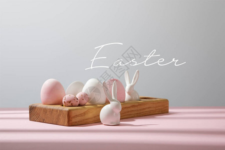 木板上的复活节鸡蛋粉色和灰色的装饰兔子图片