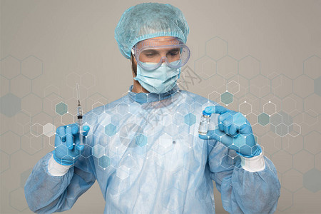 医用面具和防护谷歌的医生持有一罐疫苗和注射器图片