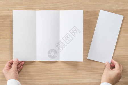 三折小册子模拟传单小册子设计A4大小的纸在商人的手中背景图片