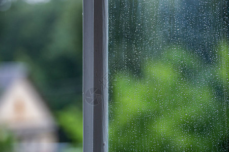 湿窗玻璃的抽象背景与雨水滴夏季冷绿色模糊背景和选择焦图片