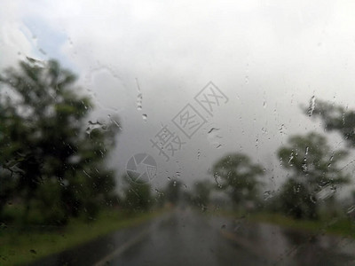 雨季抽象背景下雨滴在汽车玻璃窗上图片