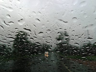 雨季抽象背景下雨滴在汽车玻璃窗上图片