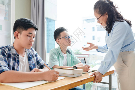 数学教师向在校学生解释难读的题材图片