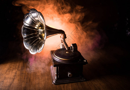 音乐概念深色背景上的旧留声机带圆盘的复古留声机在木桌上背景图片