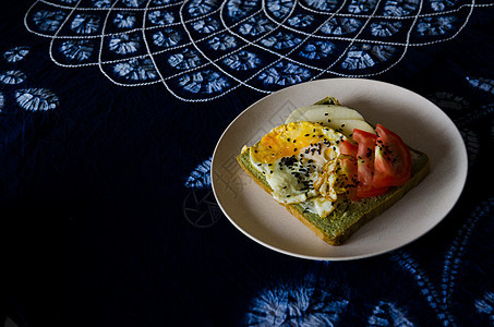 在民族风桌布上的鸡蛋番茄起司的西式早餐图片
