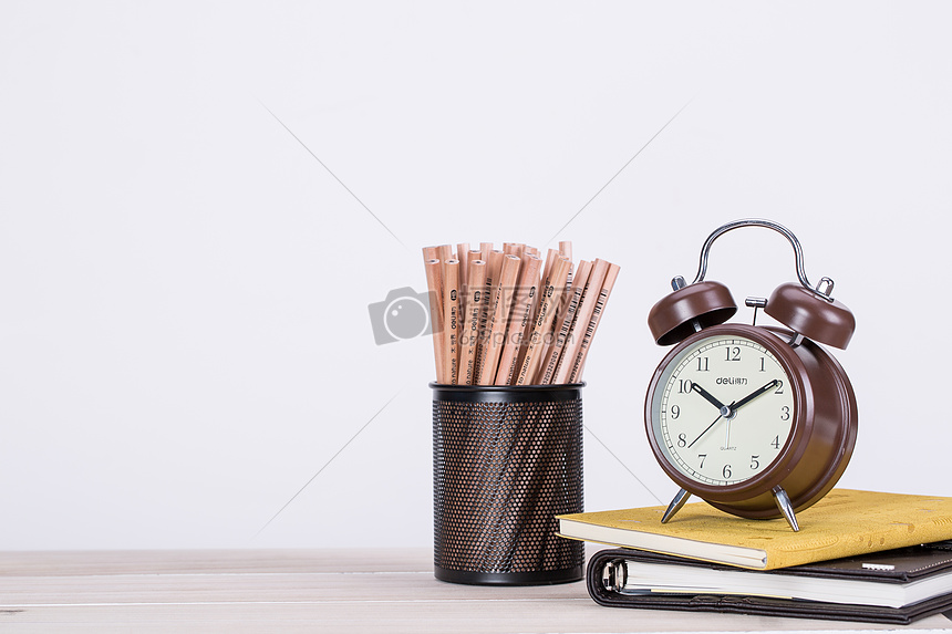 桌子上的铅笔闹钟书本图片