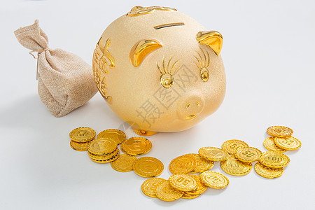 财富梦想金色的存钱罐前摆放着金币背景