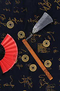 中国风红色纸扇铜钱书签摆拍背景图片
