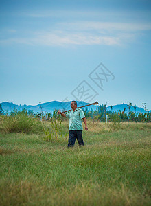 清晨农夫在山下田地草地劳动背景图片